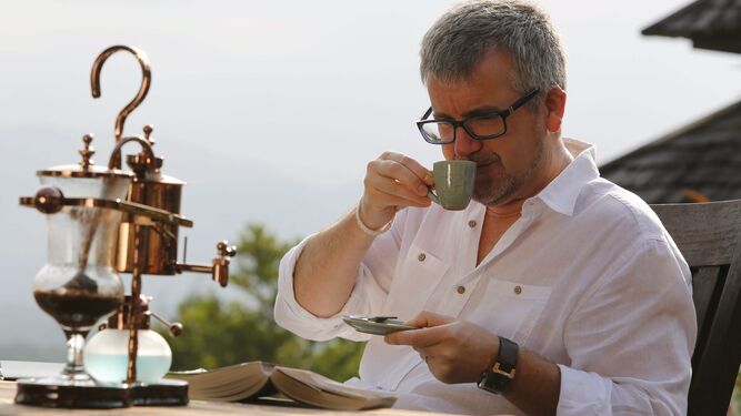 Un hombre disfruta de un café mientras lee un libro