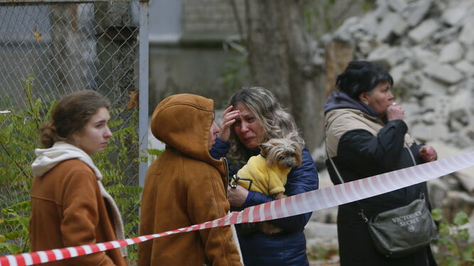 Varias ucranianas reaccionan al ver los destrozos en un edificio residencial tras un ataque en Mykolaiv.