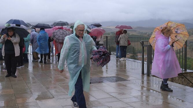 Turistas en el mirador de Ronda cargados de paraguas y chubasqueros.