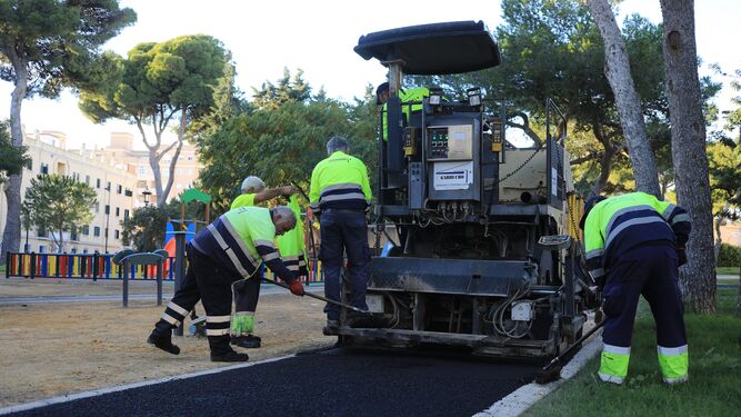 Operarios trabajando en labores de asfaltado de una obra municipal.