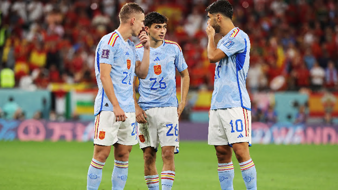 Dani Olmo, Pedri y Asensio intercambian sus pareceres durante un receso del partido.