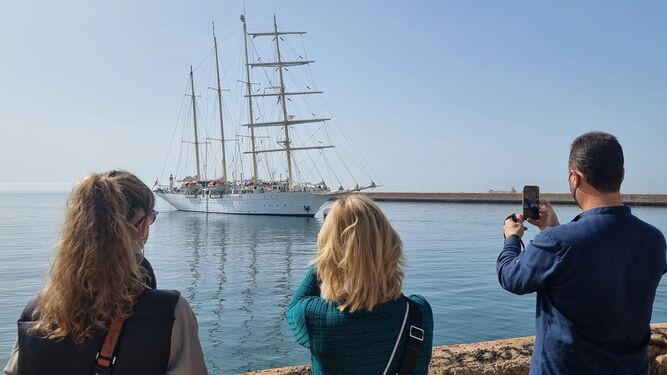 Unos turistas observan un crucero en el Puerto de Almería.