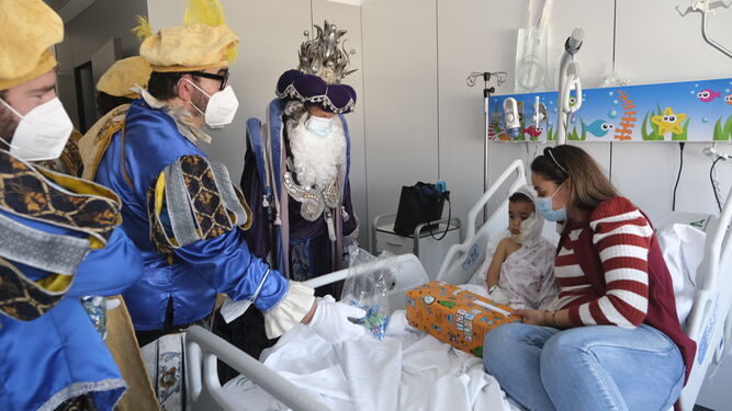 Los Reyes Magos con un niño en el Hospital de Torrecárdenas.