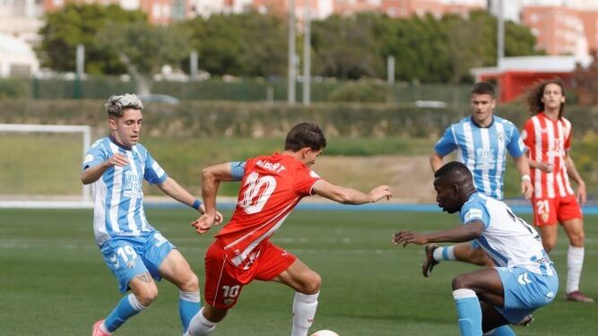 Carlos Gilbert trata de regatear a un rival durante el encuentro disputado con el Atlético Malagueño.