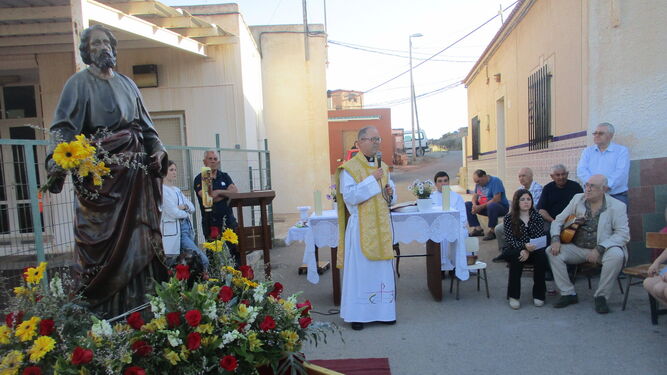 Un centenar de vecinos de la barriada almeriense escucharon la misa en la plaza e incluso en balcones cercanos.