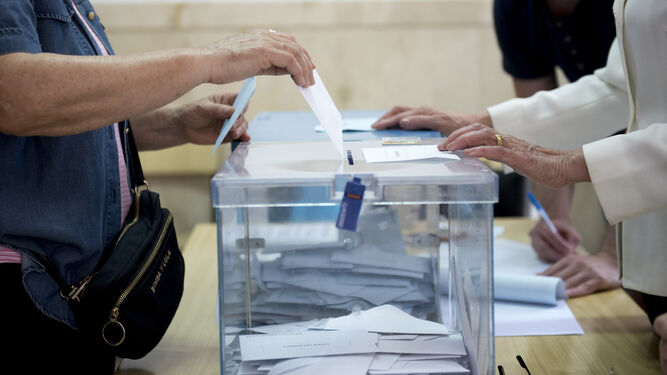 Una persona introduce su voto en una urna durante las municipales de 2019.
