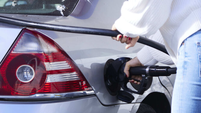 Una mujer echa gasolina a su vehículo
