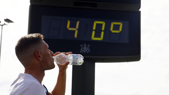 Un joven bebe agua al pasar por un termómetro en Córdoba.