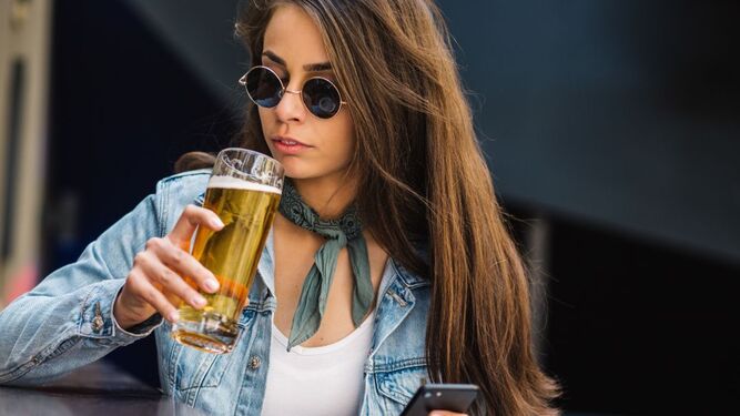 Una joven se dispone a beber una cerveza
