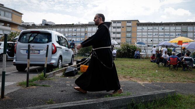 Un fraile franciscano pasa junto a los periodistas que hacen guardia ante el hospital Gemelli.