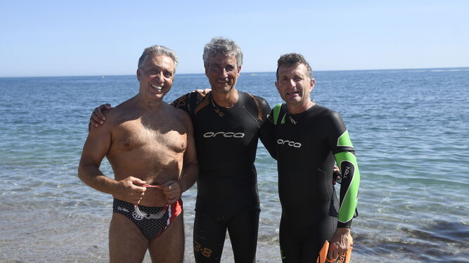 Los nadadores Manuel Carlos Peña (i), Amós Milton (c) y Antonio Huete (d) se preparan para realizar un entrenamiento en la playa de El Zapillo
