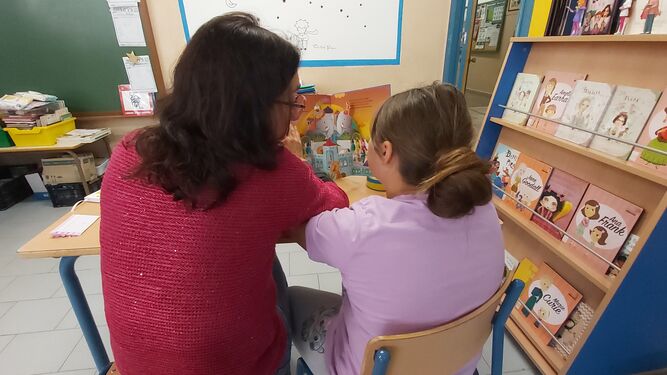 Una voluntaria leyendo con una niña en una de las sesiones de Lecxit.