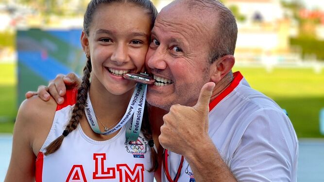 La atleta Mónica Gómez posa junto a su entrenador con la medalla de bronce en el Campeonato de Andalucía Absoluto.