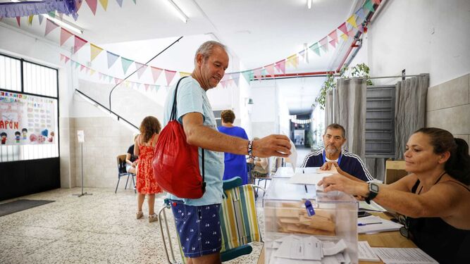 Un hombre vota en Cádiz en bañador y con su hamaca de playa.