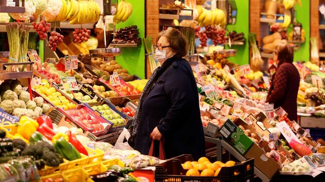 Una mujer mayor compra fruta en un supermercado.