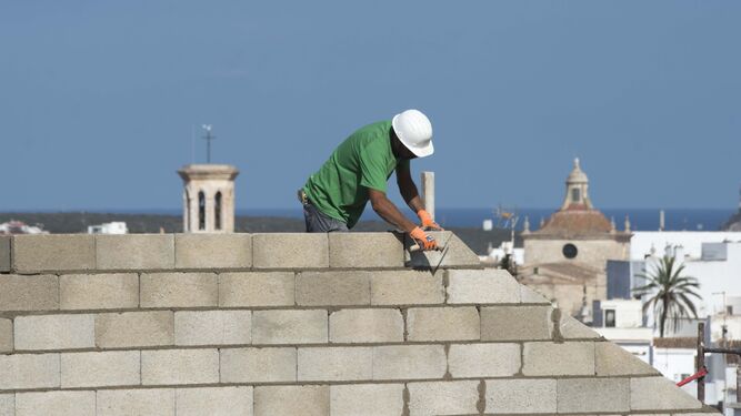 Una persona construyendo un muro.