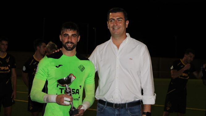 El meta Manu Martínez, capitán del Poli Almería, recibe el trofeo tras superar al Comarca de Níjar.