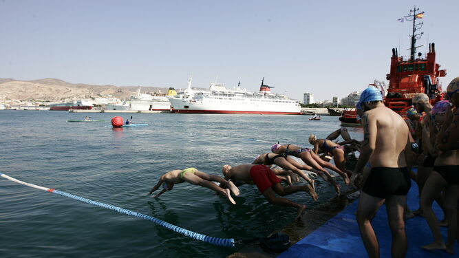 Deportistas se lanzan al agua durante una edición anterior de la Travesía a Nado celebrada durante la Feria de Almería.