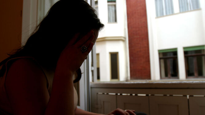 Una mujer con síntomas de depresión se lleva su mano derecha a la cabeza ante la preocupación.
