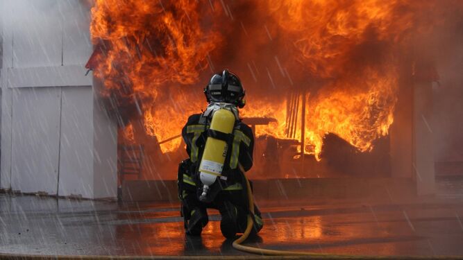 Un bombero apaga un incendio en las jornadas de puertas abiertas del Parque de Almería