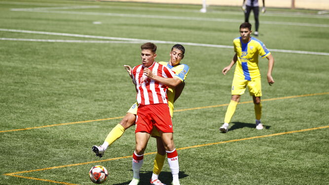 El delantero rojiblanco Pablo Castillo se faja con un rival por hacerse con la posesión del balón.