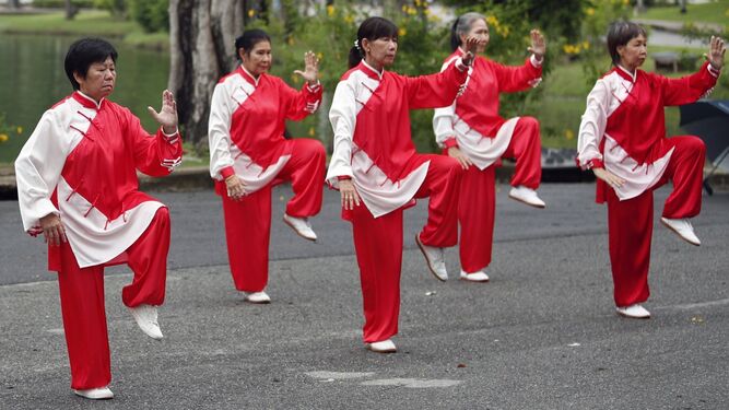 Un grupo de mujeres realizan una exhibición de taichí en un parque de Bangkok.