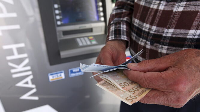 Un ciudadano saca dinero de un cajero automático.