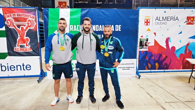 Dos de los campeones del Halterejido posan con sus medallas junto a su entrenador.