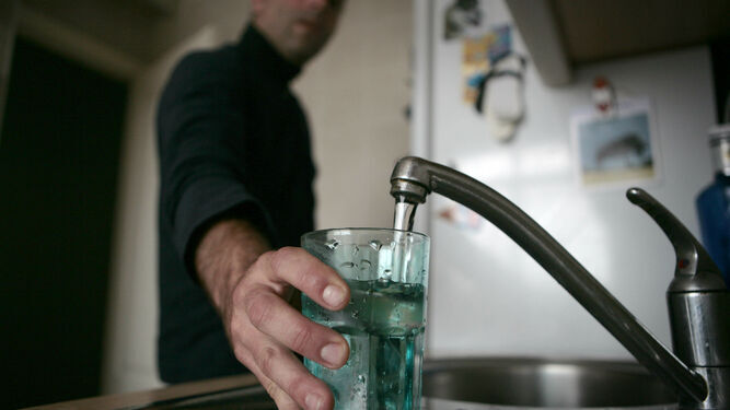 Un hombre en su domicilio llenando un vaso de agua del grifo, en una imagen de archivo.