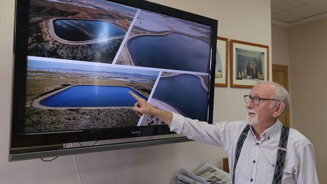 Antonio López, presidente de la CUCN, señala imágenes de balsas de almacenamiento de agua de la comunidad.