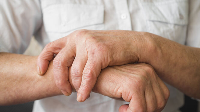 Una persona de avanzada edad se toca la muñeca de su mano derecha.