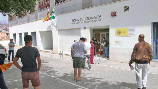 Varias personas esperan en la puerta de la Oficina de Extranjeros de Almería.