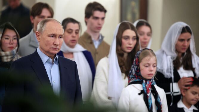 El presidente ruso, Vladimir Putin, en la misa del Gallo junto a familiares de caídos en la guerra.