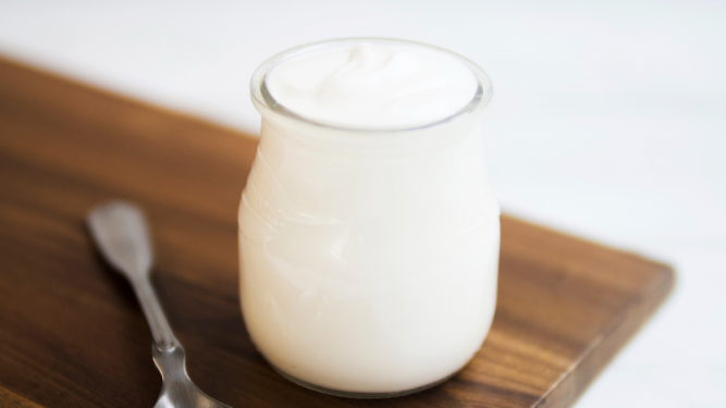 Yogur natural en recipiente de cristal.