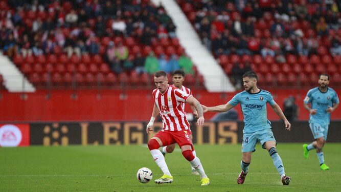 El delantero serbio trata de sortear la presión de un rival durante el encuentro frente a Osasuna.